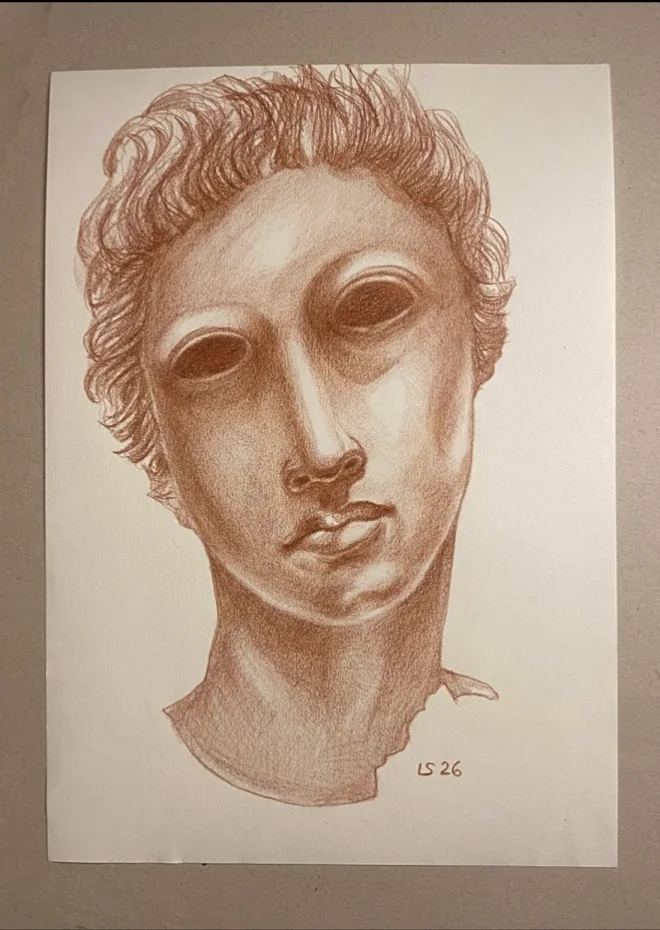 Disegno a sanguigna di Luca Sanna raffigurante la testa di Apollo di Serdica: capelli mossi, orbite scure e modellato morbido del volto.